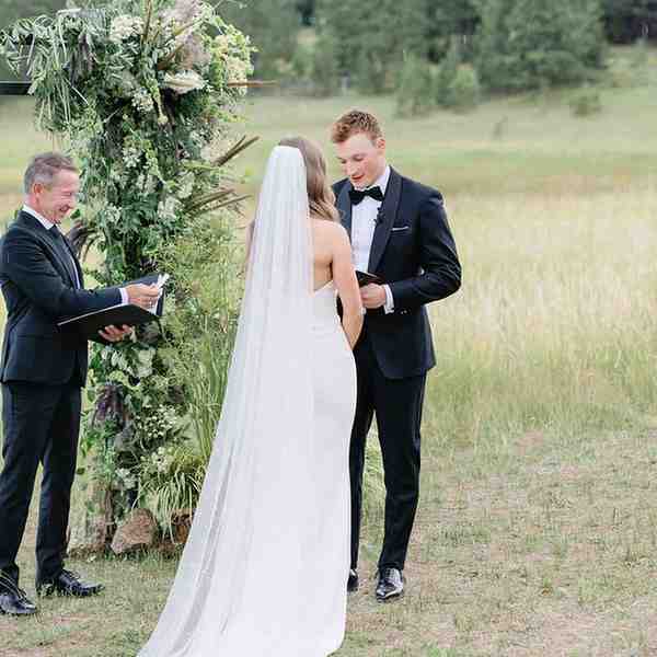 Close-up of groom's hands holding handwritten vow card