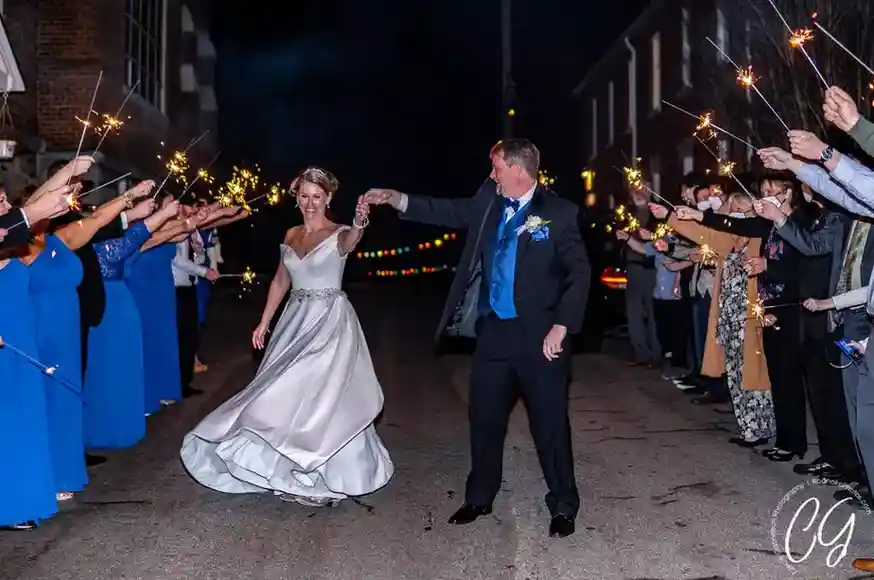 Couple with wedding sparklers exit tunnel