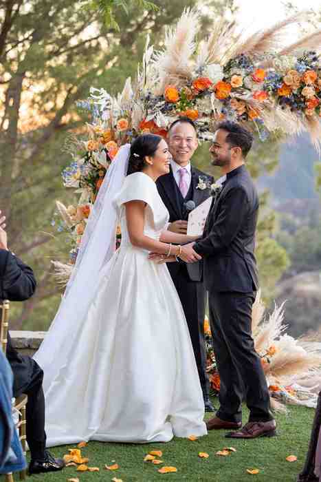 Groom and bride holding hands during vow exchange