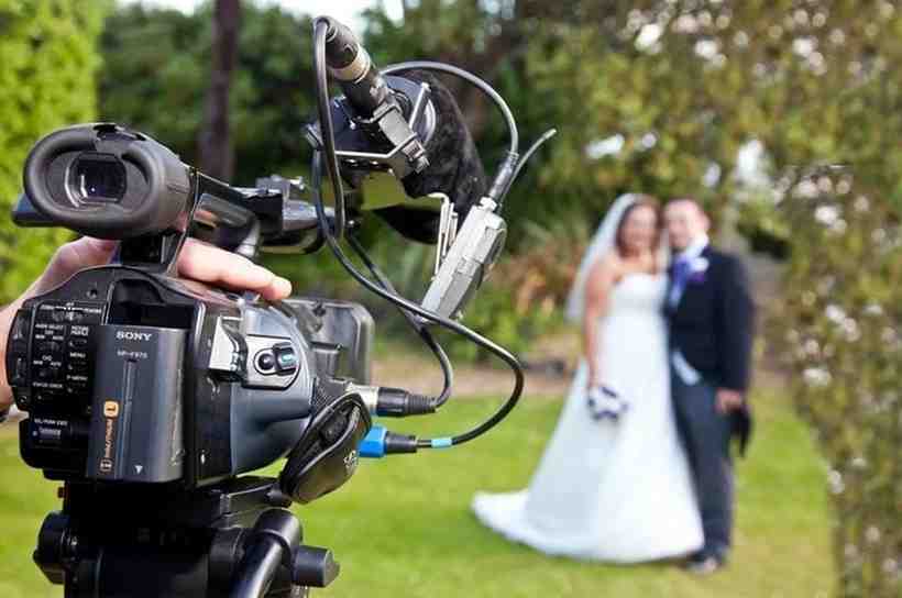 Professional wedding videographer filming ceremony