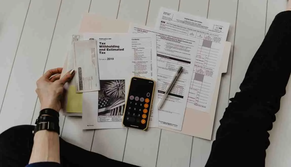 A simple wedding budget spreadsheet and a calculator on a desk